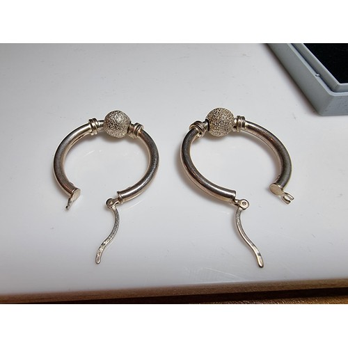 228 - A pair of 925 silver hoop earrings with a glittery ball design. In good clean condition, boxed. Diam... 