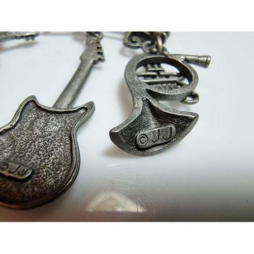 229 - An unusual music related pewter brooch featuring 4 drops which are different instruments presented o... 