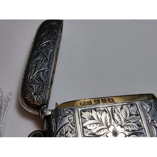 231 - A good quality antique hallmarked silver vesta case with an ornate engraved design to both sides, fe... 