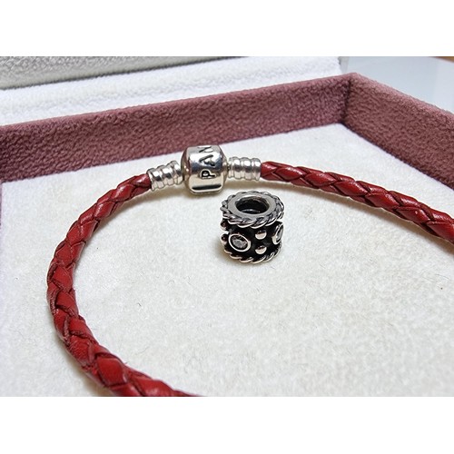 235 - A genuine Pandora 925 silver and leather bracelet complete with a genuine Pandora 925 silver charm, ... 