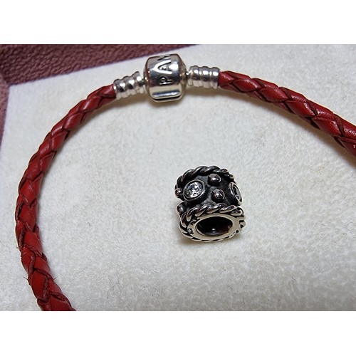 235 - A genuine Pandora 925 silver and leather bracelet complete with a genuine Pandora 925 silver charm, ... 