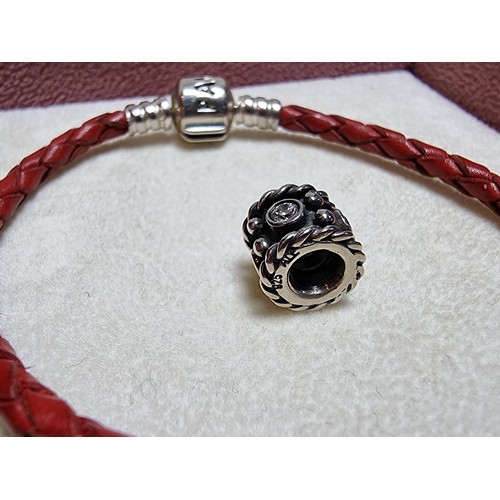 235 - A genuine Pandora 925 silver and leather bracelet complete with a genuine Pandora 925 silver charm, ... 