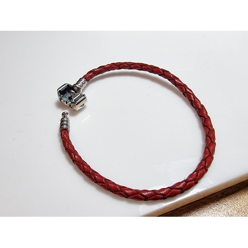 235 - A genuine Pandora 925 silver and leather bracelet complete with a genuine Pandora 925 silver charm, ... 