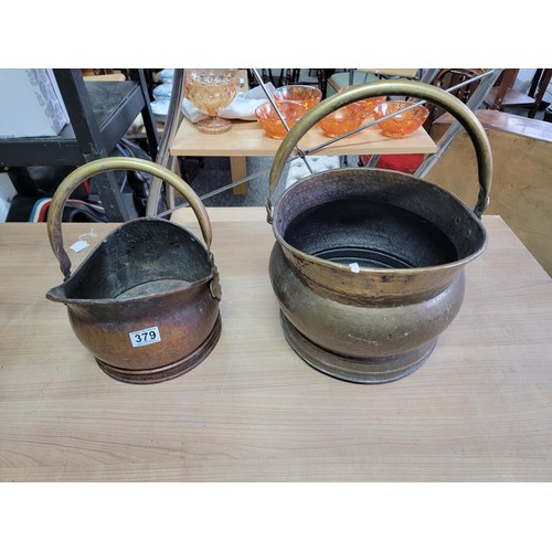 380 - Large brass double handled brass coal bucket along with a smaller double handled copper coal bucket,... 