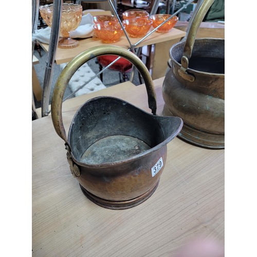 380 - Large brass double handled brass coal bucket along with a smaller double handled copper coal bucket,... 