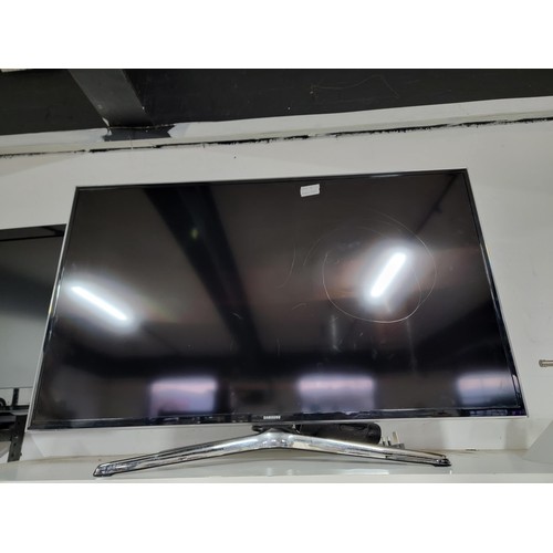 414 - Samsung 40 inch flat screen TV complete with power cable and remote controls standing on a chrome st... 