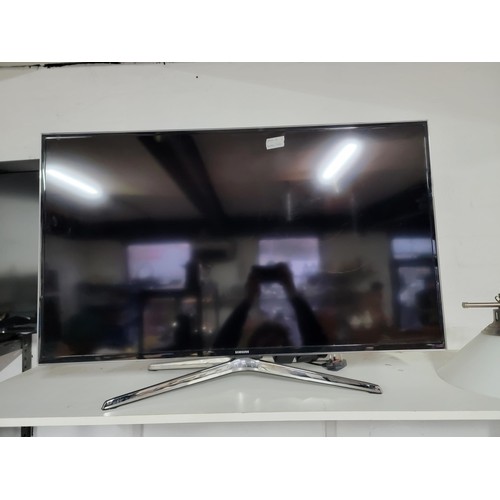 414 - Samsung 40 inch flat screen TV complete with power cable and remote controls standing on a chrome st... 