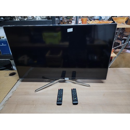 414 - Samsung 40 inch flat screen TV complete with power cable and remote controls standing on a chrome st... 