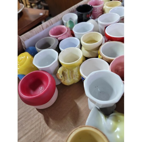 437 - Box containing a large quantity of 30 plus egg cups of various designs inc train formed, dog, rabbit... 