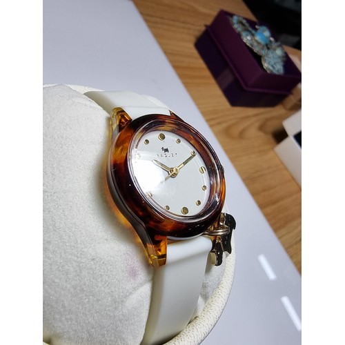 241 - A ladies unused Radley watch with faux tortoise shell case and a white strap featuring a Radley dog ... 