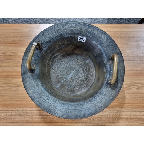 273 - A large antique Chinese bronze singing bowl with a dragon design featuring a yin yang and character ... 