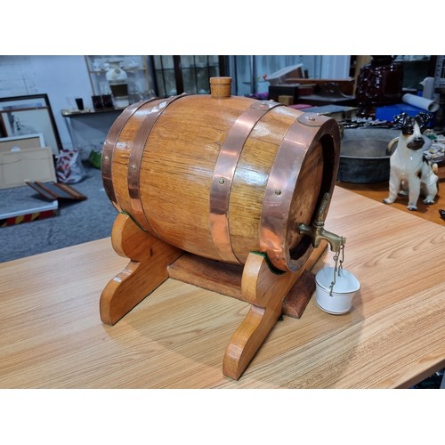 271 - A good quality vintage solid oak copper bound barrel keg on its original stand with a wooden stopper... 