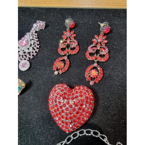 278 - A suite of as new glitzy jewelled jewellery including matching necklace and earring set with pink an... 