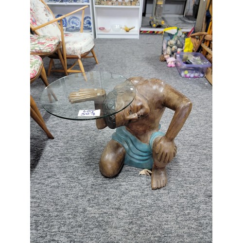 506 - A wooden carved man kneeling and holding a round glass tray/table made of safety glass. He is solid ... 