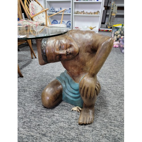 506 - A wooden carved man kneeling and holding a round glass tray/table made of safety glass. He is solid ... 