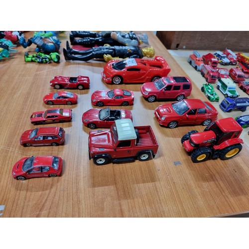 21 - A collection of 12 red die-cast cars to include a red Britain's Land Rover, a Burago, Ferrari 250 te... 