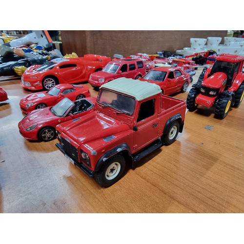 21 - A collection of 12 red die-cast cars to include a red Britain's Land Rover, a Burago, Ferrari 250 te... 