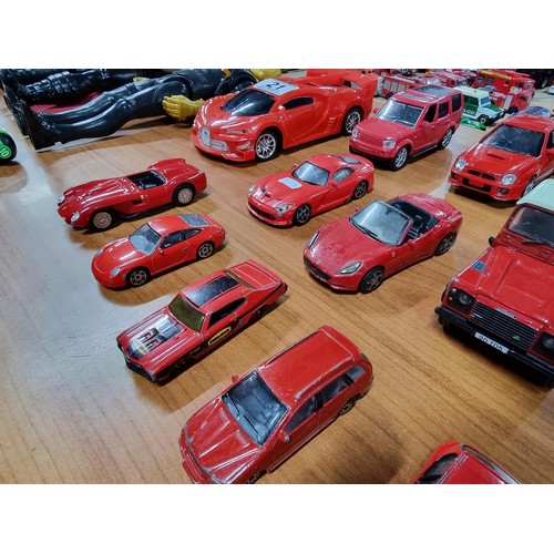 21 - A collection of 12 red die-cast cars to include a red Britain's Land Rover, a Burago, Ferrari 250 te... 