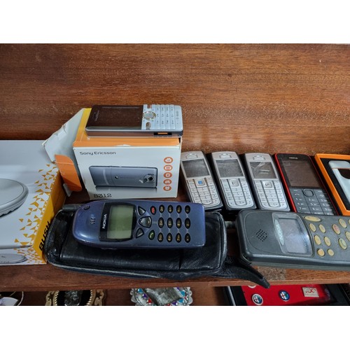 53 - A large collection of vintage mobile phones along with 2 portable CD players, 2x tom tom sat navs, a... 