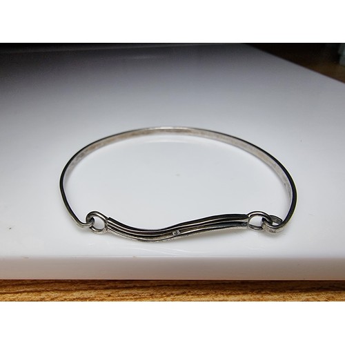 176 - 925 silver bangle featuring a genuine small diamond to the front with a wave design. In clean condit... 