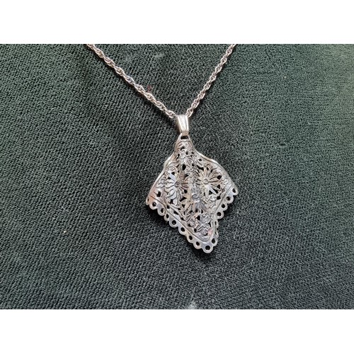 178 - Unusual 925 silver pendant featuring a pierced crinkle floral design set on a long 20