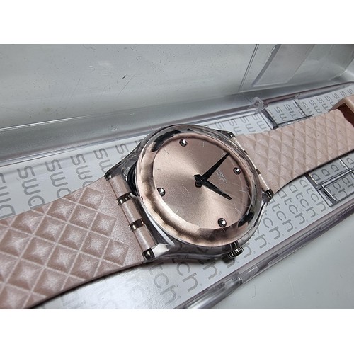 179 - Ladies Swatch wristwatch in a light pink / copper colour, fitted in its original Swatch case. In goo... 