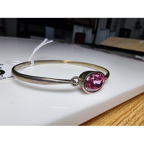 186 - Good 925 silver bangle inset with a large pink oval CZ crystal stone which is sparkly and lively, In... 