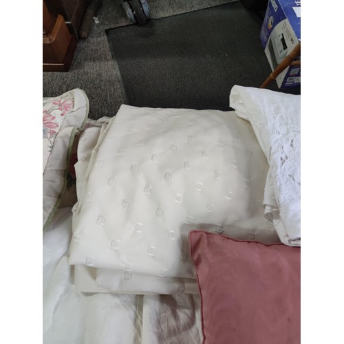 474 - A large box of assorted linen inc cushions, pair of cream curtains, table clothes inc a crocheted ta... 