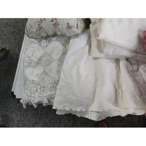 474 - A large box of assorted linen inc cushions, pair of cream curtains, table clothes inc a crocheted ta... 