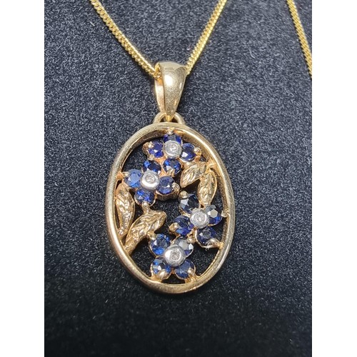 271 - Pretty hallmarked 9ct. yellow gold pendant inset with blue sapphire and diamond stones in a floral d... 