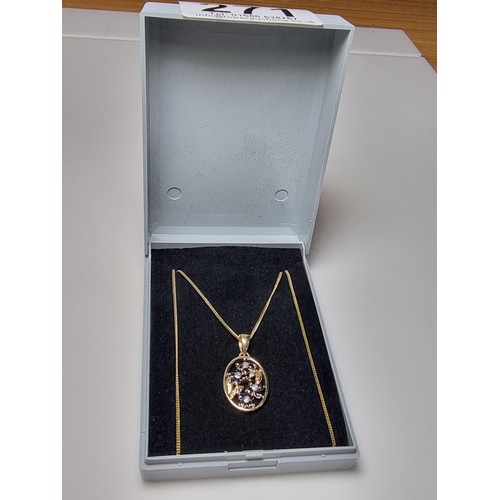 271 - Pretty hallmarked 9ct. yellow gold pendant inset with blue sapphire and diamond stones in a floral d... 