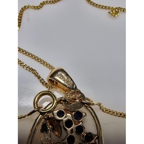 271 - Pretty hallmarked 9ct. yellow gold pendant inset with blue sapphire and diamond stones in a floral d... 