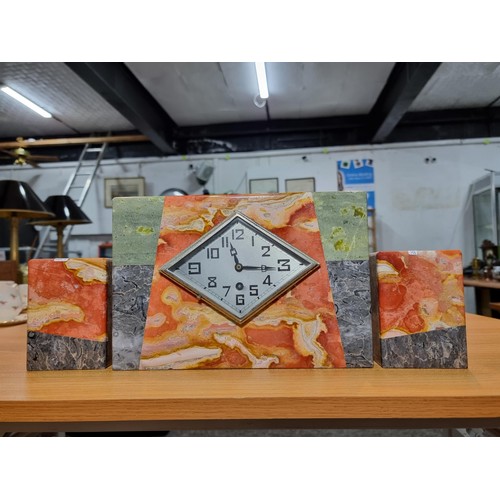 300 - An impressive French Art Deco marble mantle clock with matching garnitures, featuring four different... 