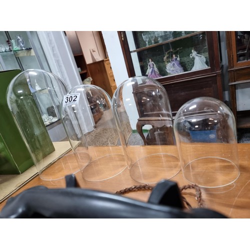 302 - Collection of 4x glass domes for displaying items in graduating sizes. Largest measures 26cm height,... 