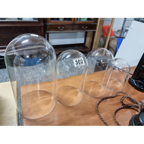 302 - Collection of 4x glass domes for displaying items in graduating sizes. Largest measures 26cm height,... 