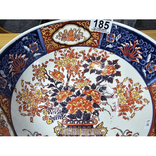 185 - A large antique Chinese bowl with a thick enamel hand painted design featuring a scene of sprays of ... 