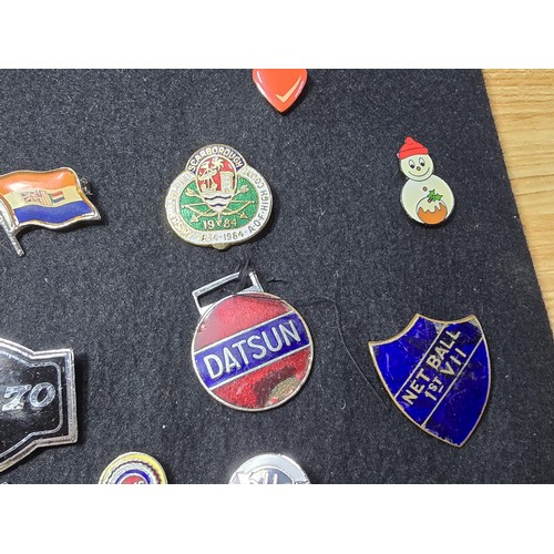 191 - A large collection of approx 35x collectable pin badges on a black display board (included) to inclu... 