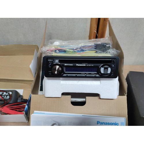 386 - A box of items inc a battery charger, as new Panasonic car cd player/radio CQ-RDP113N,  pair of spot... 