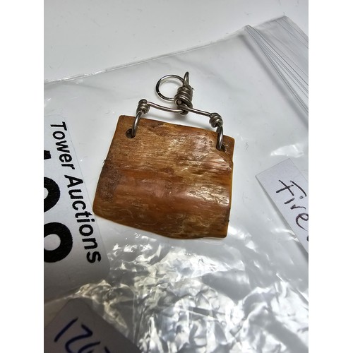 198 - An ancient fossilized Walrus tusk carved pendant inset with a genuine fire opal stone, having good g... 