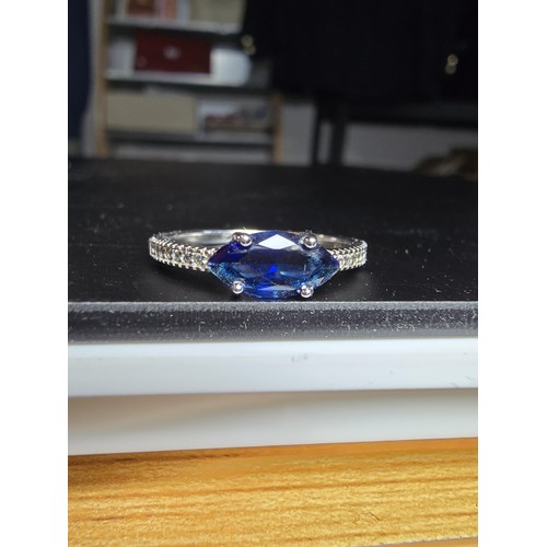 204 - A pretty 925 silver ring inset with a large blue CZ crystal with smaller clear CZ crystal stones to ... 