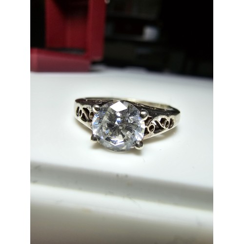 214 - A chunky 925 silver dress ring with a pierced design inset with a large CZ crystal sparkly stone. In... 