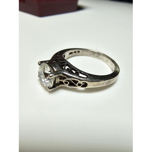 214 - A chunky 925 silver dress ring with a pierced design inset with a large CZ crystal sparkly stone. In... 