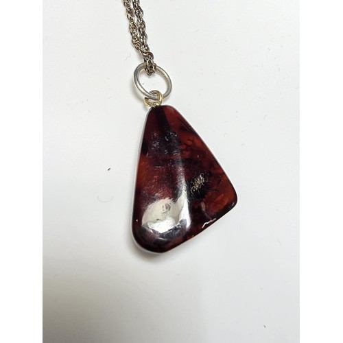 215 - A stunning deep red genuine amber pendant which displays very nicely with light shining through it. ... 