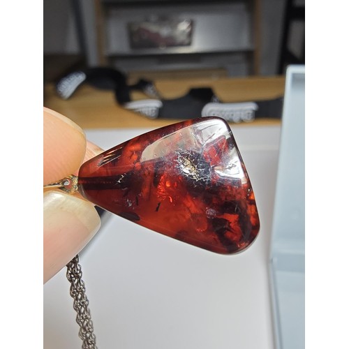 215 - A stunning deep red genuine amber pendant which displays very nicely with light shining through it. ... 