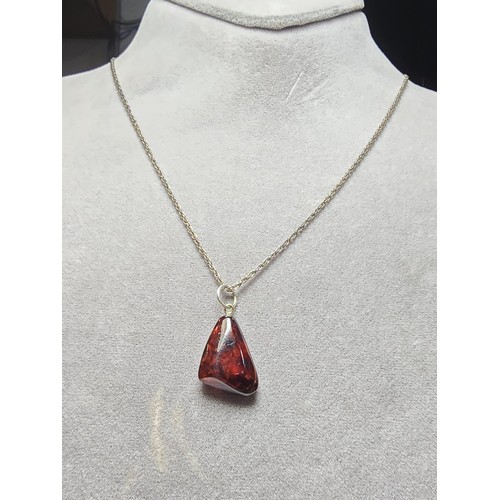 215 - A stunning deep red genuine amber pendant which displays very nicely with light shining through it. ... 