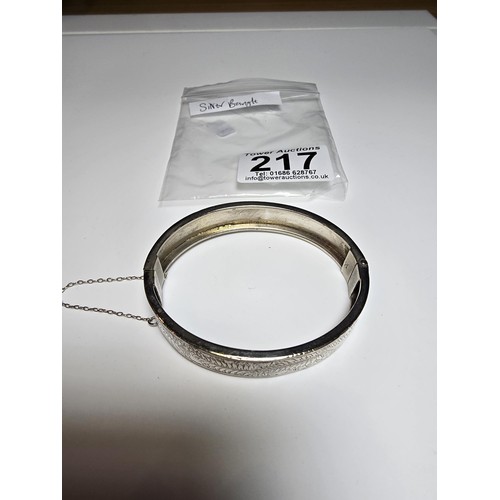 217 - A sterling silver hinged bangle with an engraved fern leaf sign, in clean condition, appears unmarke... 