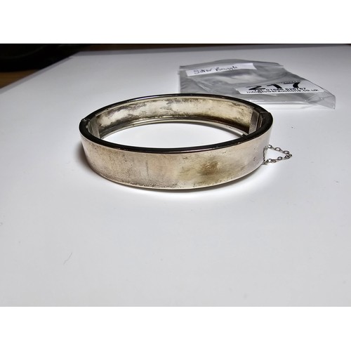 217 - A sterling silver hinged bangle with an engraved fern leaf sign, in clean condition, appears unmarke... 