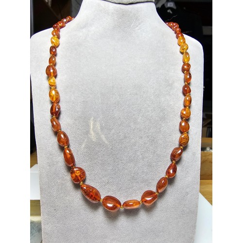 241 - A good quality vintage hand knotted genuine amber beaded necklace, each bead has an interesting natu... 