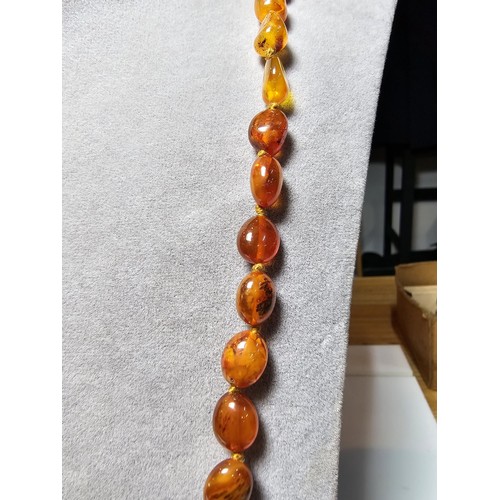 241 - A good quality vintage hand knotted genuine amber beaded necklace, each bead has an interesting natu... 