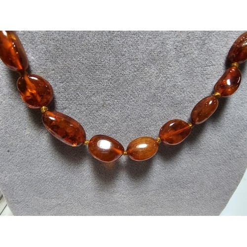 241 - A good quality vintage hand knotted genuine amber beaded necklace, each bead has an interesting natu... 